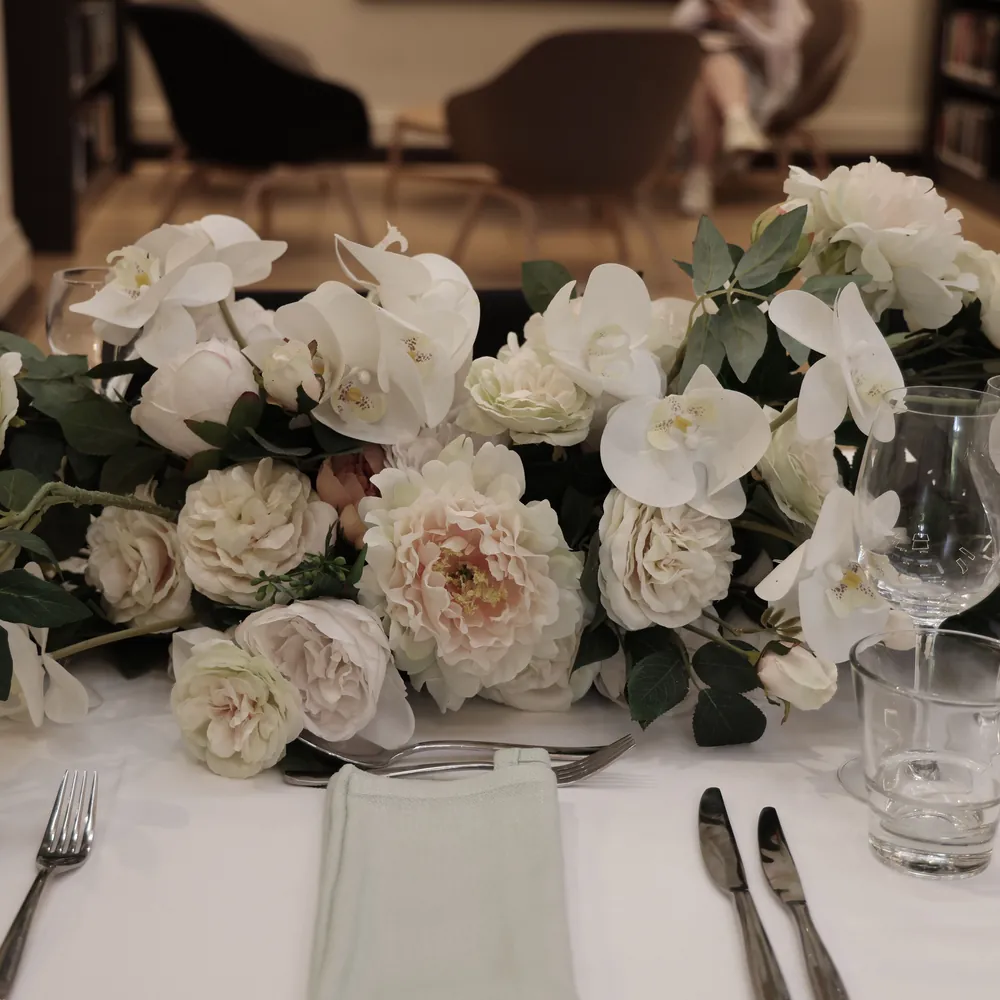 White roses and peonies arranged on a set event table