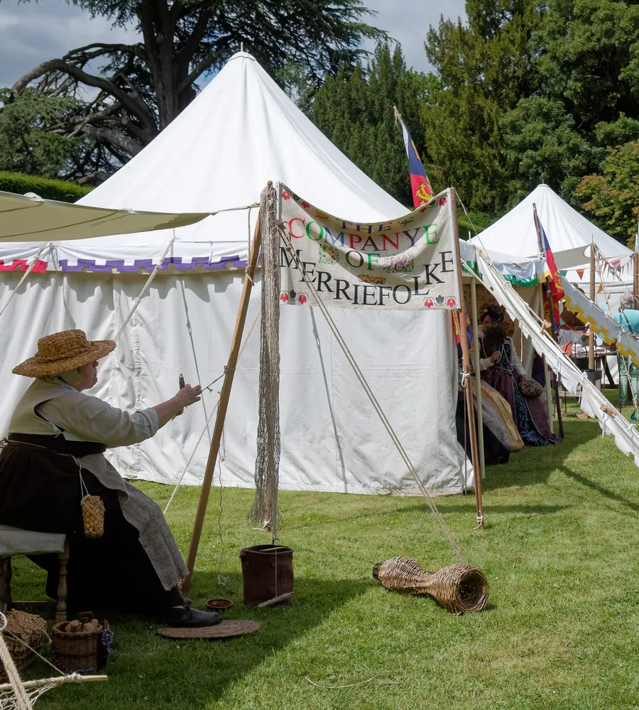 White marquee tents on a sunny lawn at an outdoor gathering